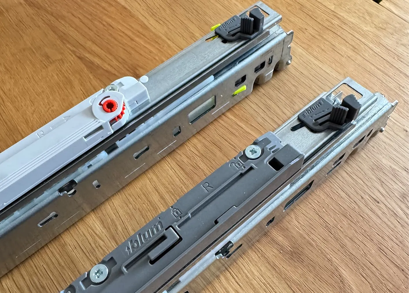 Vergleich Blum MOVENTO Schienen, oben reine TIP-ON-Variante mit orangem Stellrad für die Tiefeneinstellung, unten MOVENTO BLUMOTION ohne Stellrad