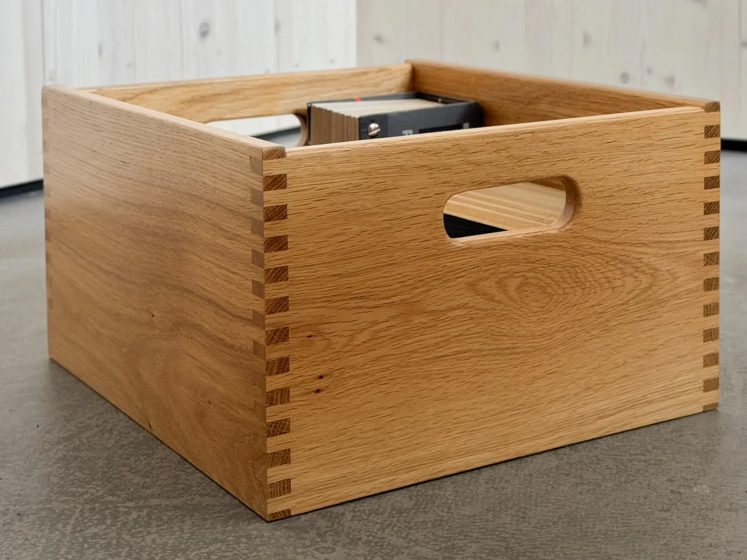 Sichtlade aus Holz mit zwei Grifffräsungen an Vorder- und Rückseite, rundum eingenuteter Boden
